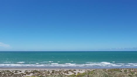 An-Einem-Windigen-Frühlingstag-Parallel-Zum-Strand-Und-Dem-Wunderschönen-Türkisfarbenen-Meer-Fliegen---Waikuku-Beach,-Pegasus-Bay
