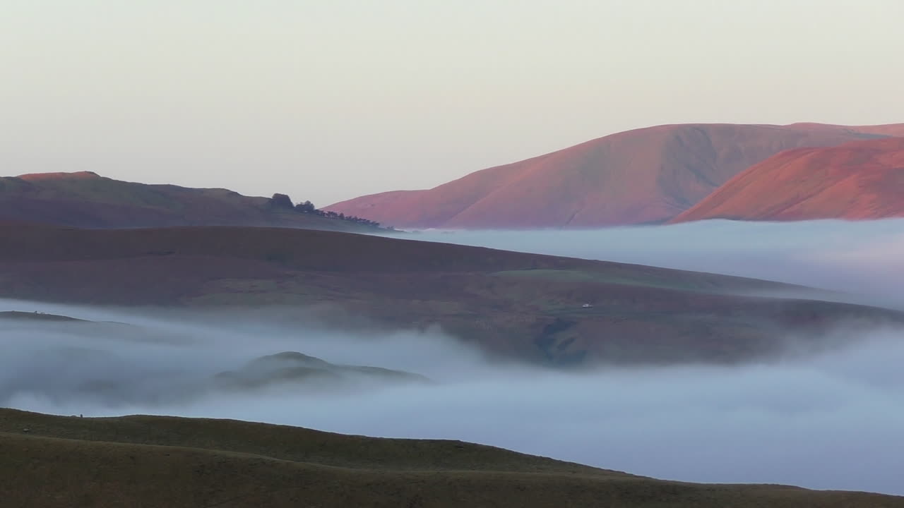 프레임 중앙에서 움직이는 작은 흰색 밴과 함께 컴브리아의 에덴 계곡을 내려다보는 이른 아침 구름 역전