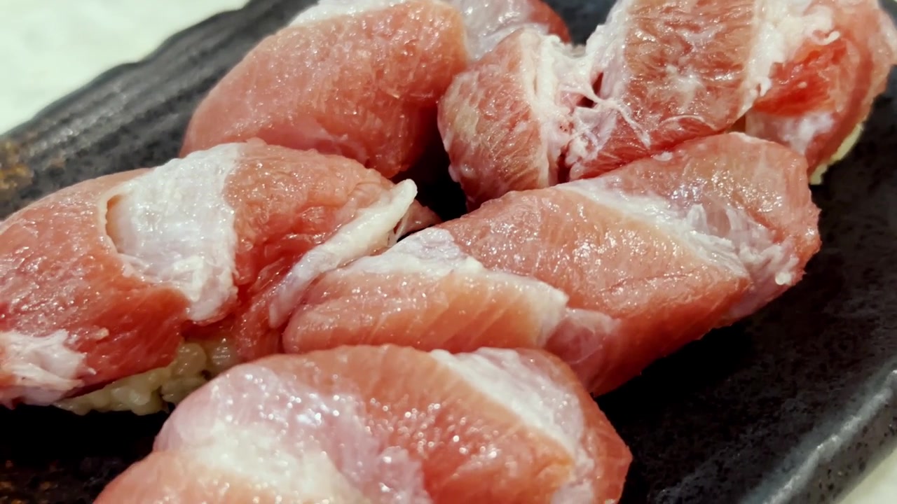豊かな霜降りの脂が乗った本マグロを特徴とする、巧みに調理され優雅な和の盛り付けで提供されるプレミアム大トロ握り寿司のクローズアップ