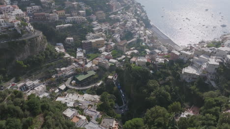 imágenes aéreas volando hacia la ciudad de positano, italia en la costa de amalfi, mostrando el tráfico en las carreteras montañosas
