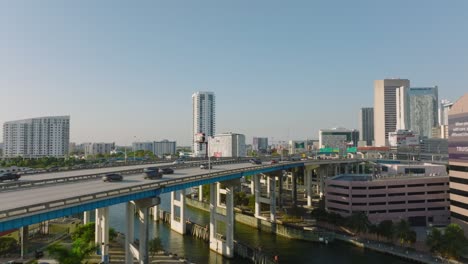 sliding reveal of traffic on highway bridge over river. vehicles driving on multilane trunk road in city. miami, usa