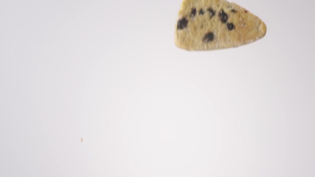 Shower of crumbly fruit-studded scones falling on bright white studio backdrop in slow motion. blueberry brand commercials, healthy breakfast content, farmers market bakery posts.