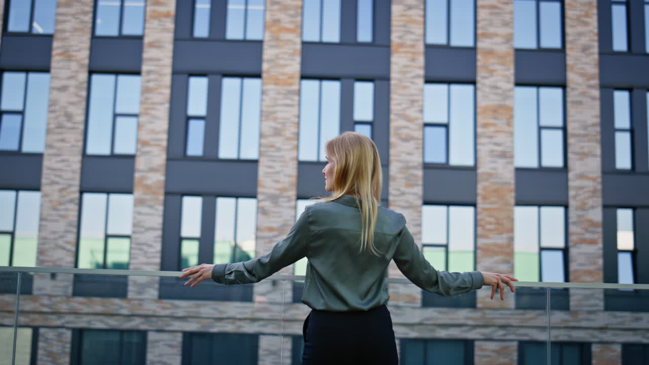 Resting businesswoman looking architecture building rear view. Woman relaxing
