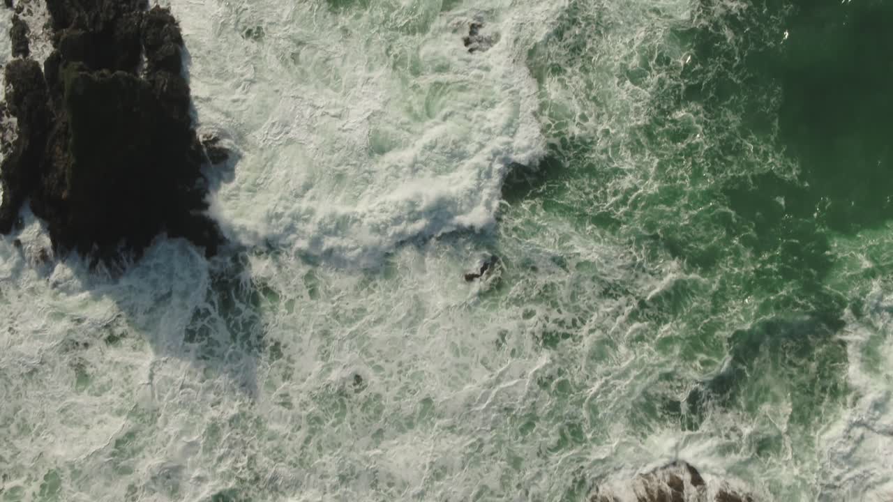 antena mirando hacia las olas rompiendo sobre las rocas hacia la orilla