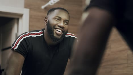 Smiling-black-man-looking-at-mirror-at-bathroom.-Portrait-of-happy-black-man