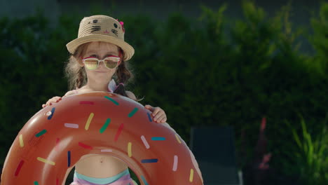 portrait of a cute little girl with an inflatable ring in her hands