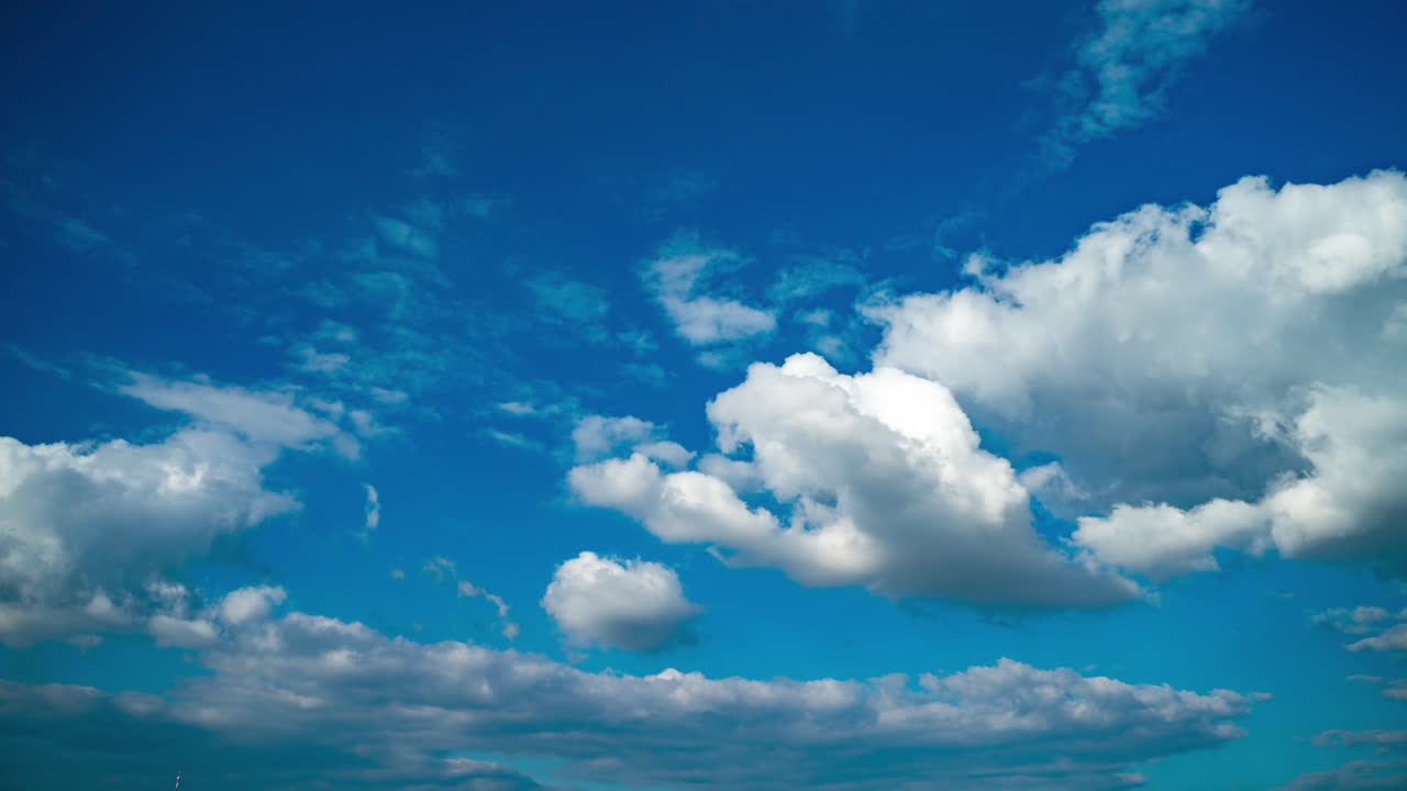 Formation of large white cumulus clouds. Evening blue sky with multi-layered clouds. Change in weather and climate