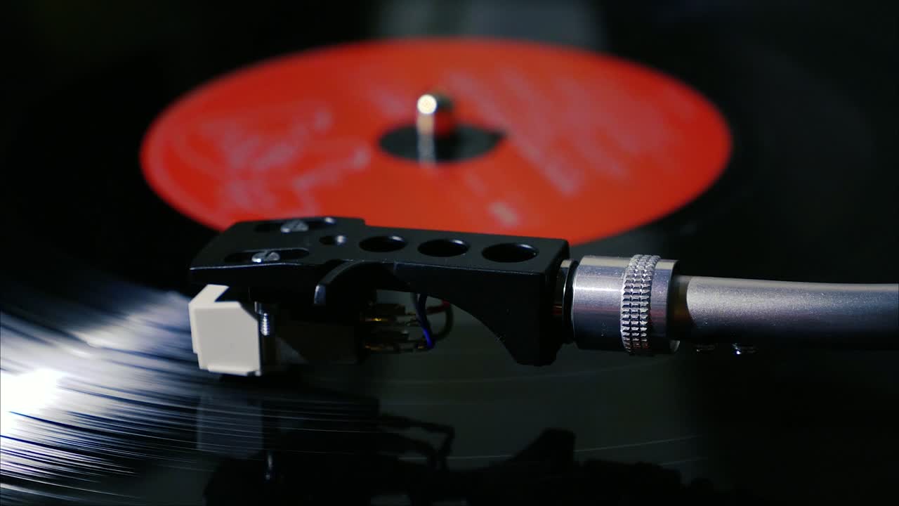 Panning shot of black vintage vinyl record spinning on a turntable