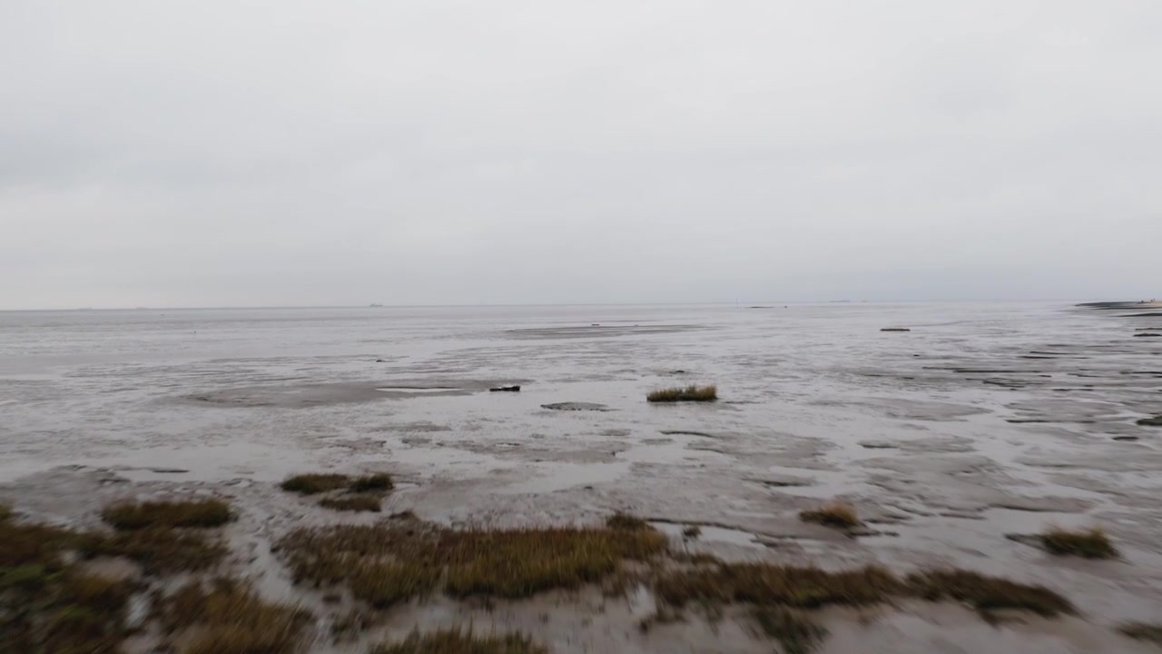Fast and high Drone flight into the North Sea at low tide gives panoramic view over the Wadden Sea, which is an UNESCO world heritage site.
