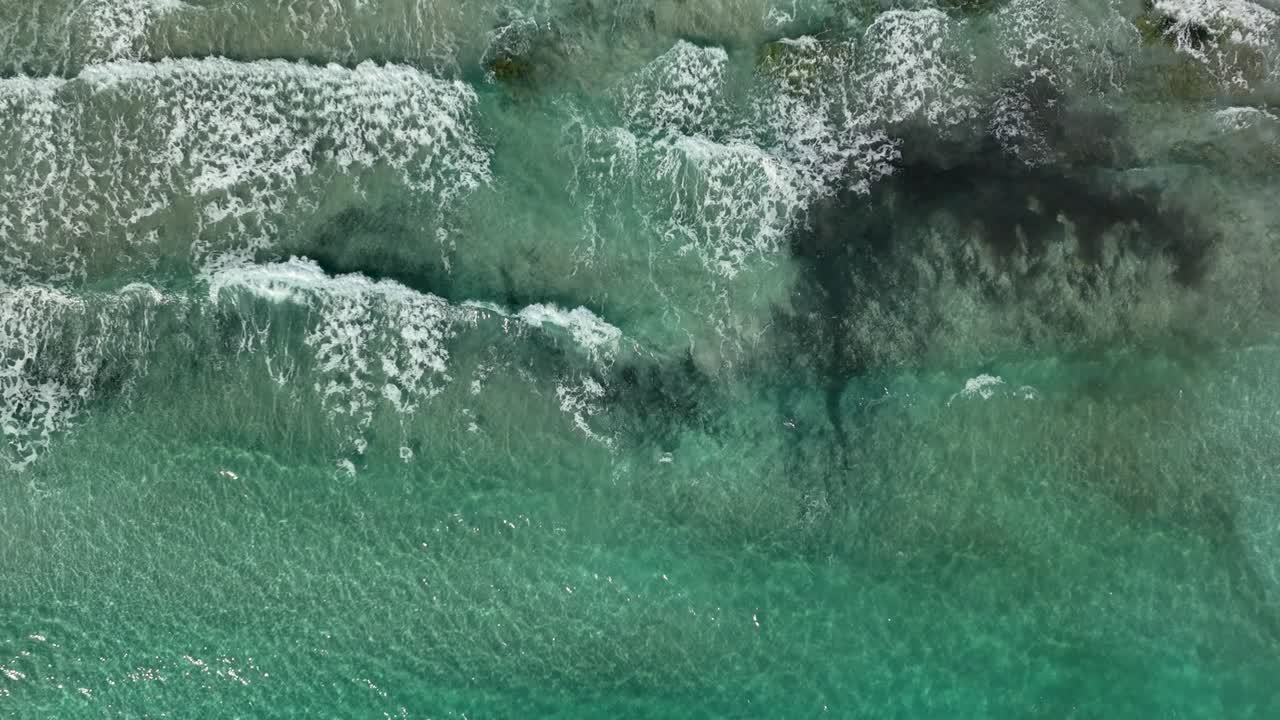vista de arriba hacia abajo de las olas golpeando la playa en cámara lenta en el futuro