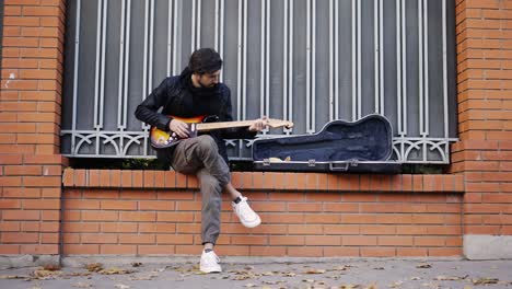 el tipo tocando el guitar en la calle