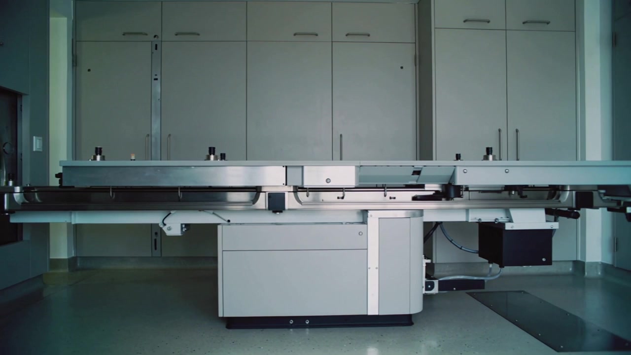 Motor starting moving patient table showing drive unit toward scanner bore in imaging room for scan