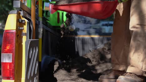 hombre excavando la suciedad de la parte trasera de una camioneta