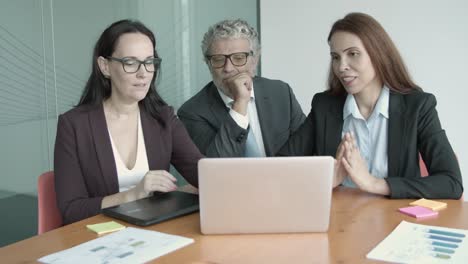 Content-businesspeople-looking-presentation-on-laptop