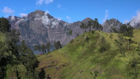 Trapped-clouds-in-the-crater-lake-of-Mount-Rinjani-active-volcano-in-Indonesia,-Aerial-dolly-left-reveal-shot