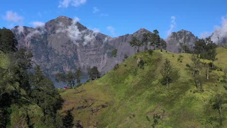 nubes atrapadas en el lago del cráter del volcán activo monte rinjani en indonesia, toma aérea izquierda revelada