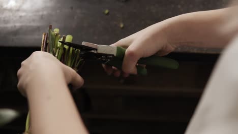 delicate, female hands cut the stems of flowers with a pruner. cut pieces fall to the floor. aiming shooting