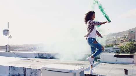 fashionable young woman on urban rooftop using a smoke grenade