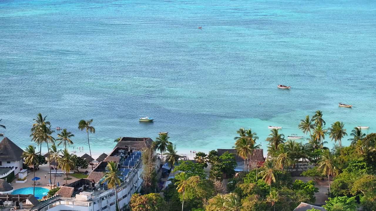 Zanzibar’daki tropikal sahil tesisleri ve okyanus boyunca uçan sinematik drone 3x zoom çekimi. Detaylı sahil şeridi, turkuaz su ve lüks sahil atmosferi çarpıcı bir seyahat ve tatil sahnesi yaratıyor