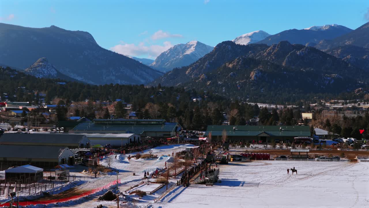 Evento de Ski Joring a cavalo, multidões no Recinto de Feiras de Estes, Parque Nacional das Montanhas Rochosas, cidade de montanha Estes Park Colorado, drone aéreo, manhã fria de inverno, neve fresca, nuvens, céu azul, ensolarado, Lago Estes, círculo à esquerda