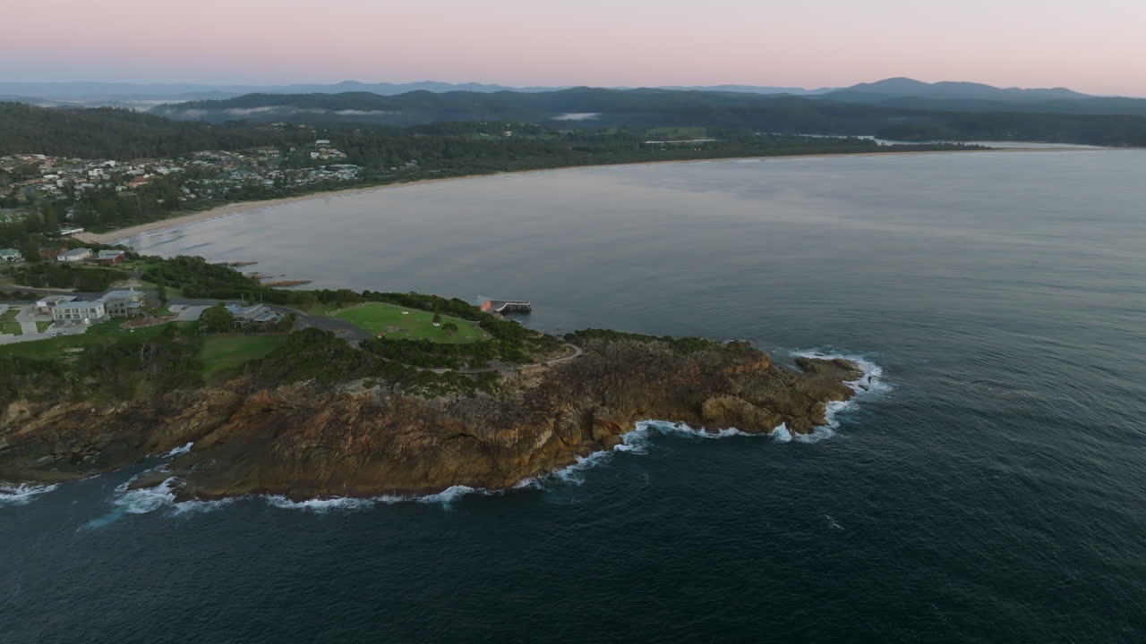 Aerial: Drone shot of Tathra headland early morning before the sun rises, South Coast NSW, Australia