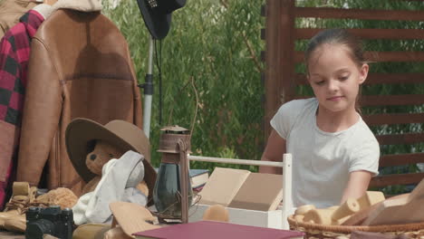 little girl having garage sale