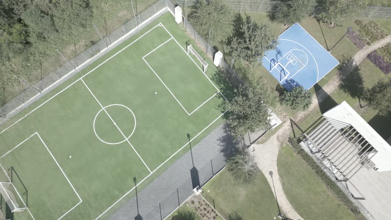 Aerial shot overhead a half basketball court and football field in a community