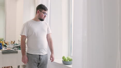 boy picking an apple from a fruit bowl and then he eats it