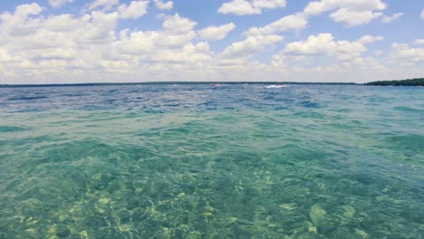 pov boat ride on a crystal clear glacial lake on a sunny summer day