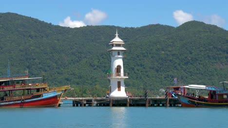 plano general de barcos estacionados en un muelle que tiene un faro
