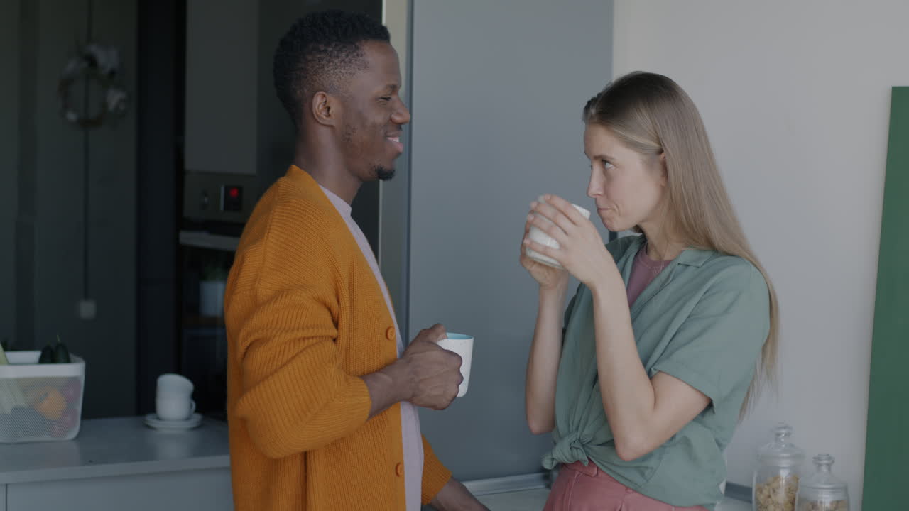 Par nyder kaffe i køkkenet.