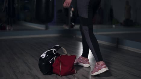 young fit woman entering a fitness club with a bag and boxing gloves and preparing for the training in a boxing club. shot in 4k