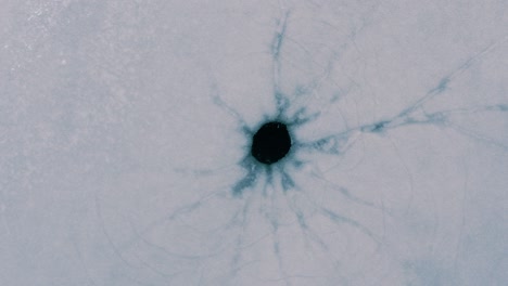 round hole in a frozen lake. a natural hole from an underwater spring