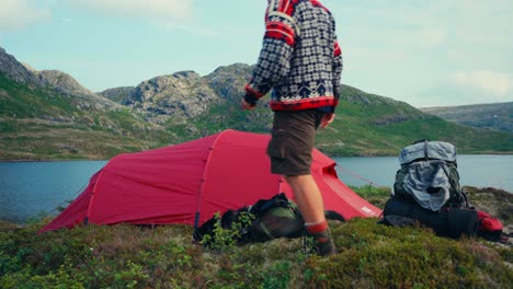 caucasian man with camping tent near palvatnet lake in trondelag county, norway