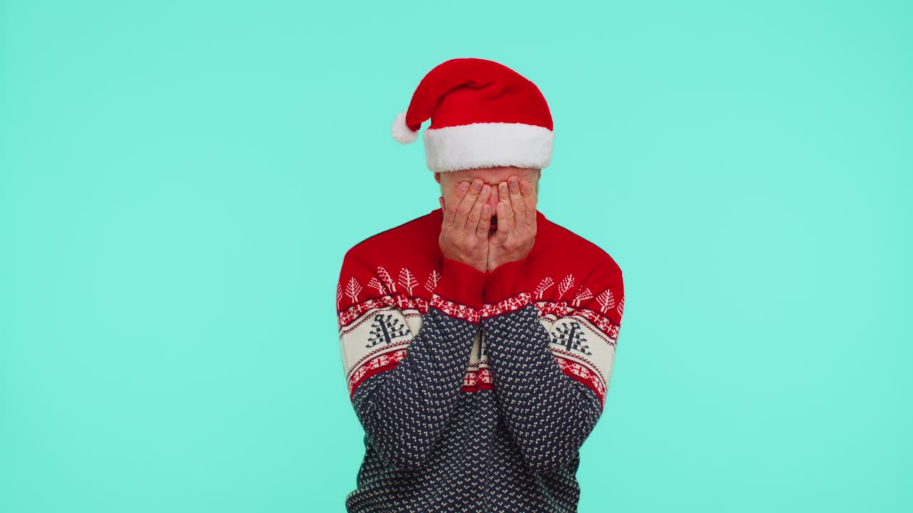 은 새해 스웨터를 입은 실망한 남자가 눈물을 고 절망에서 울며 선물을 받지 못했습니다.