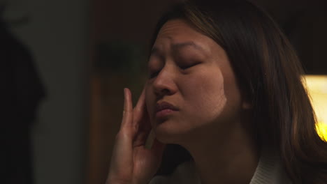 Close-Up-Of-Stressed-Or-Anxious-Woman-Suffering-With-Depression-Anxiety-Loneliness-Sitting-In-Darkened-Room-At-Home