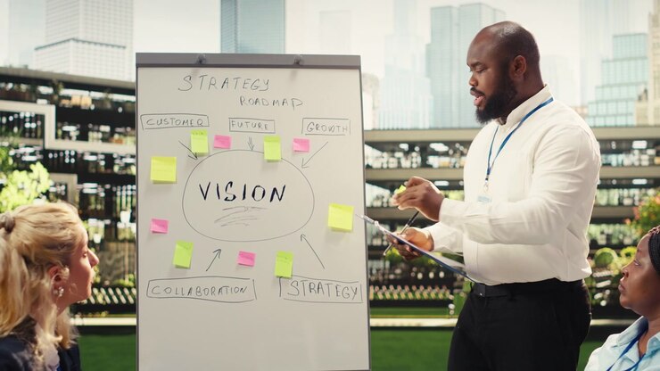 Businessman leading presentation and pointing at board in informal meeting