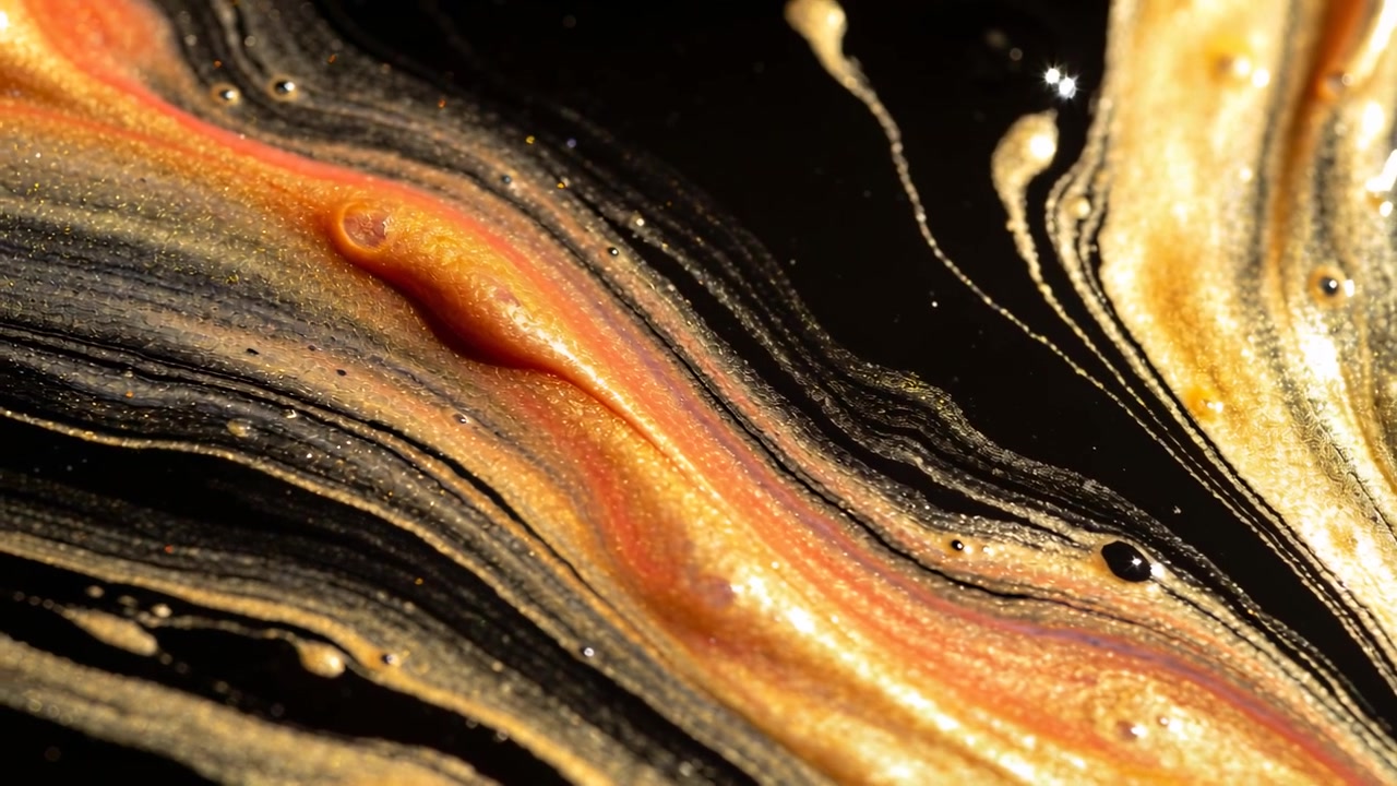 Flowing gold band rippling and thickening in studio macro, creating droplets from slow fluid motion