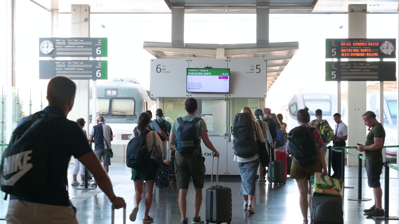 Passengers pass through a train boarding checkpoint for Renfe, Spain's national state-owned railway company, at Alicante station in Alicante, Spain.