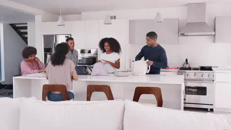 Familia-Negra-En-Su-Cocina,-Desempacando-Alimentos-Y-Guardándolos-Juntos.