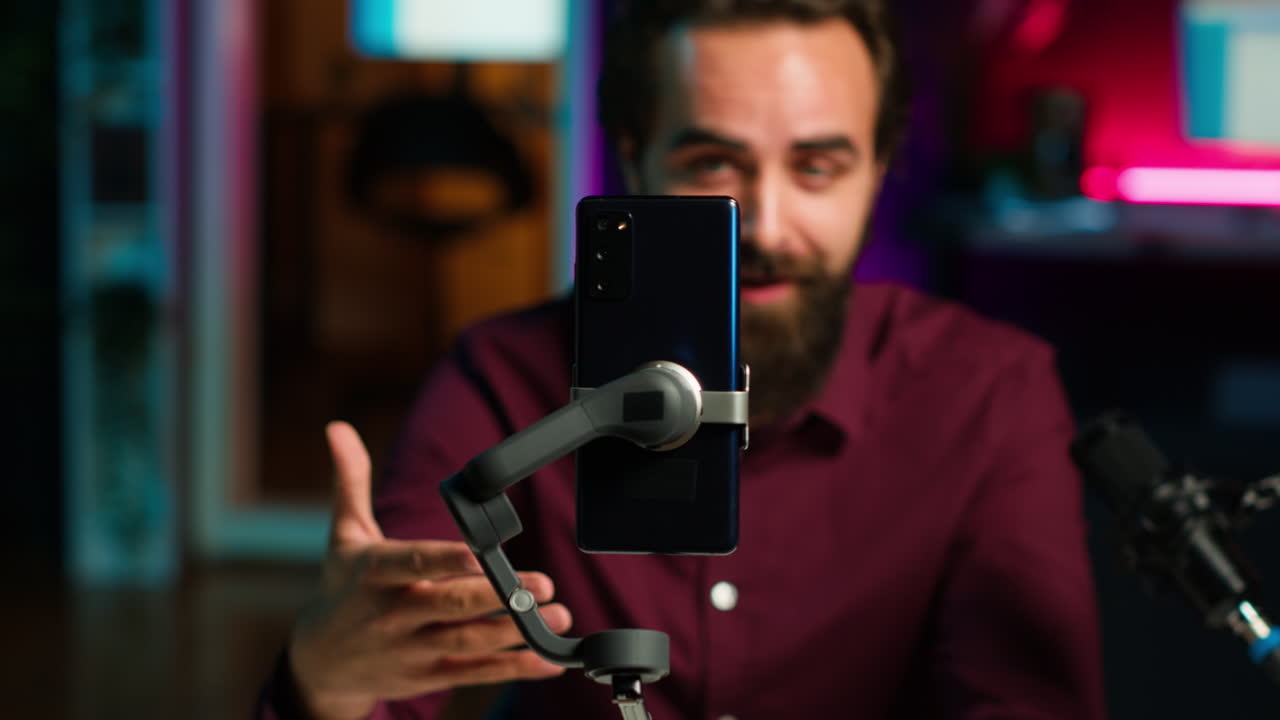 enfoque en el teléfono móvil en el palo de selfie utilizado por el influyente en el estudio de grabación en vivo