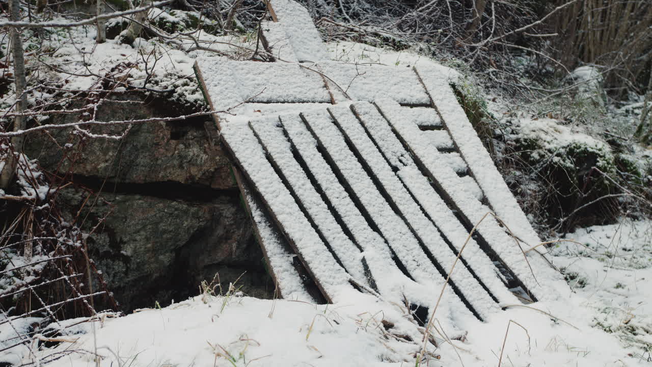 Planks and rocks covered with snow on a bright winter day