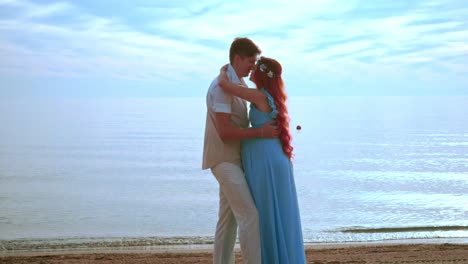 young people kissing on sea beach. pregnant couple kissing. happy couple beach