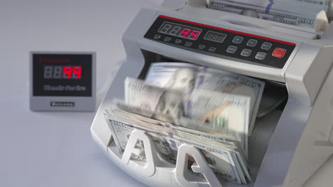 male puts a wad of us dollars into money machine. equipment for financial operations working. high angle view. close up.