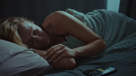 woman sleeping in bed with phone