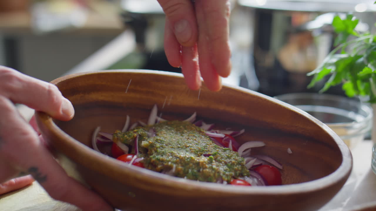 Hands of Chef Salting Salad