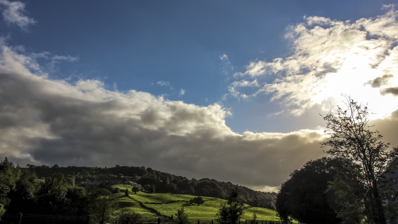 Tipico paesaggio rurale inglese, colline ondulate, alberi e nuvole spettacolari