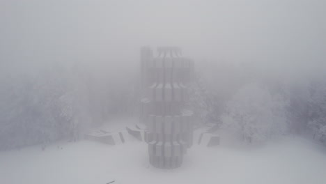 aerial view of monument to the revolution in kozara, bosnia and herzegovina in the foggy winter