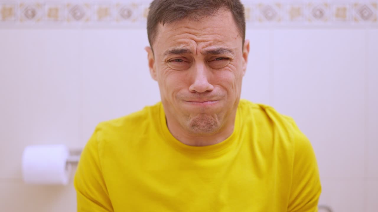 Man struggling with constipation on the toilet