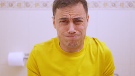 man struggling with constipation on the toilet